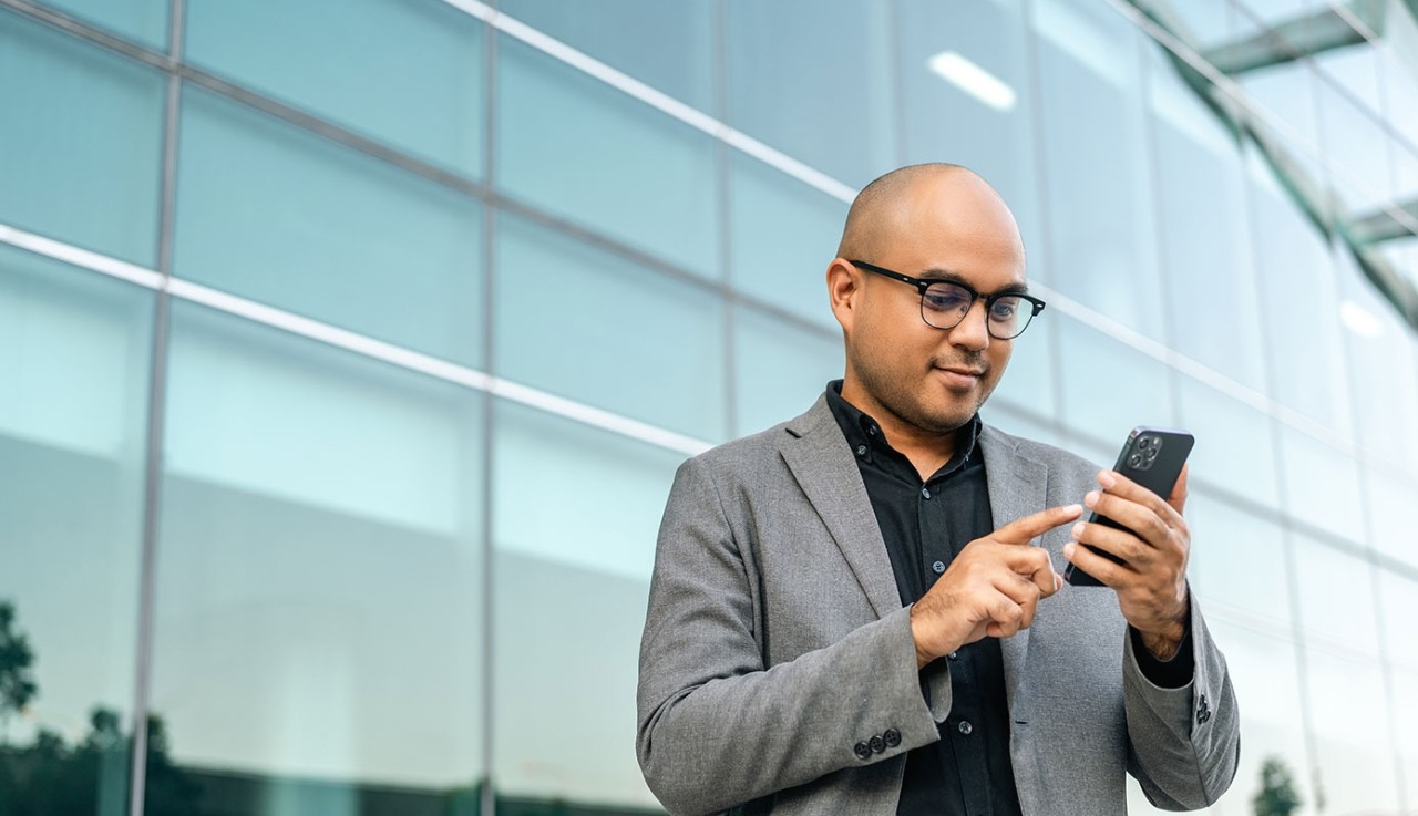Senior manager business man in suit with cell phone at the buildings downtown. Confident man using smartphone looking towards their goals for success. Executive business man