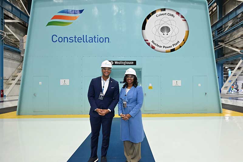 Visitors including Maryland's Gov. Wes Moore, in safety gear standing in front of Constellation turbine generator at Calvert Cliffs Nuclear Power Plant
