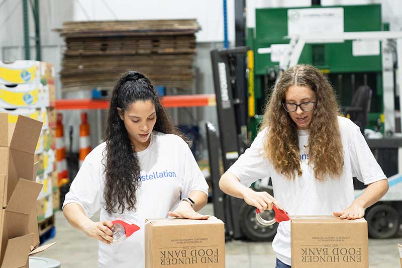 Constellation volunteers packing boxes for End Hunger Food Bank to fight food insecurity