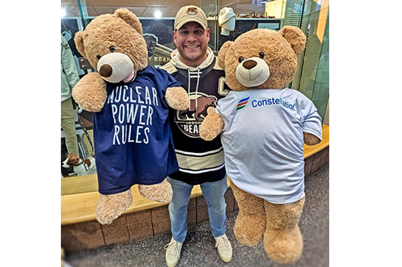 Employee holding teddy bears with constellation logos