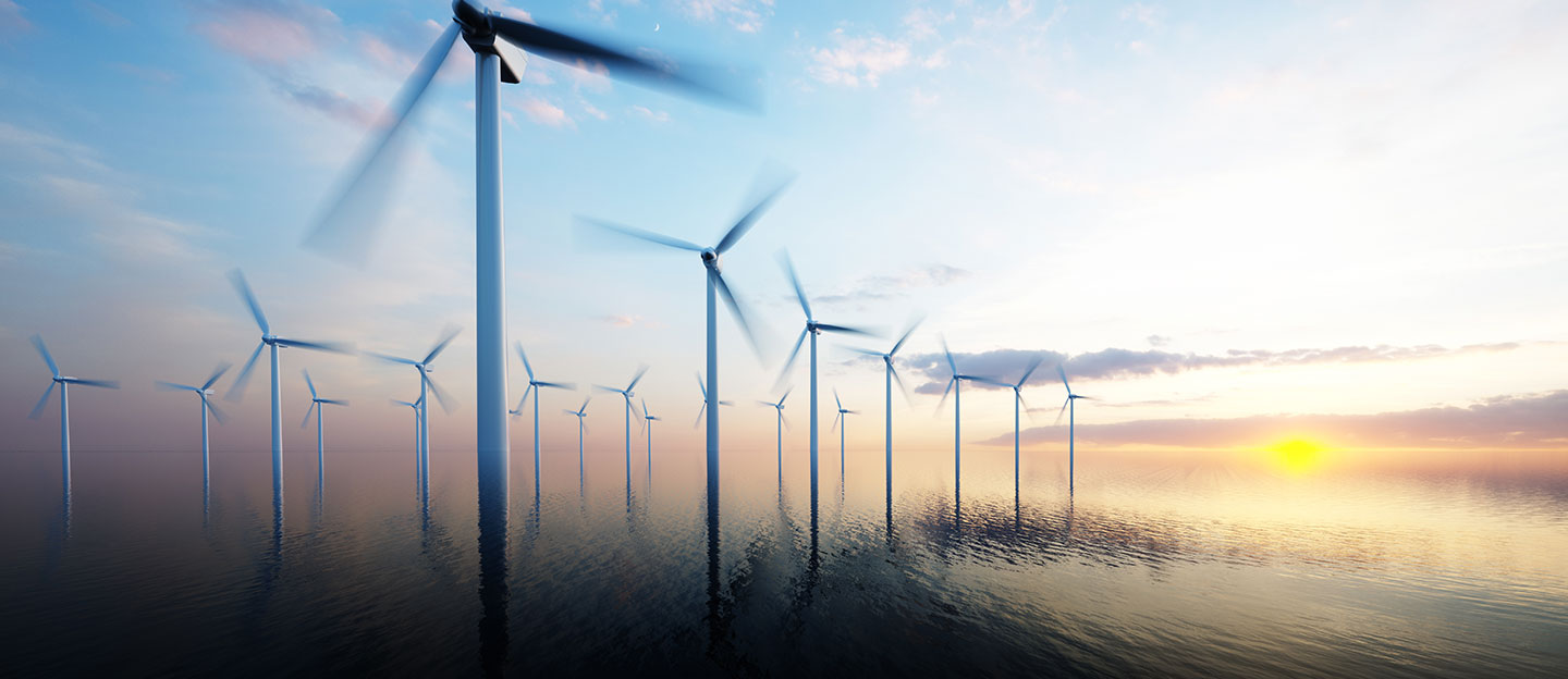Wind turbines in water with sun in background