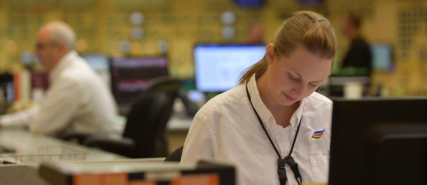 female constellation employee looking down working in control room