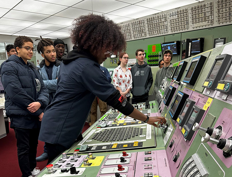 Kids around a control room touching equipment