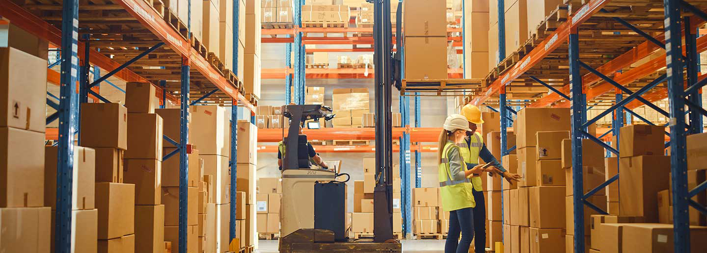 Two employees in a warehouse looking at boxes
