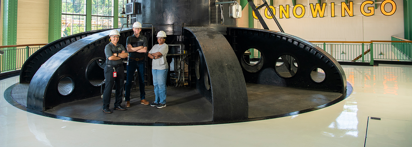 Team standing on turbine at Conowingo hydroelectric plant